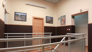 Un hall d’hôtel avec une porte en bois, un escalier et une rampe.