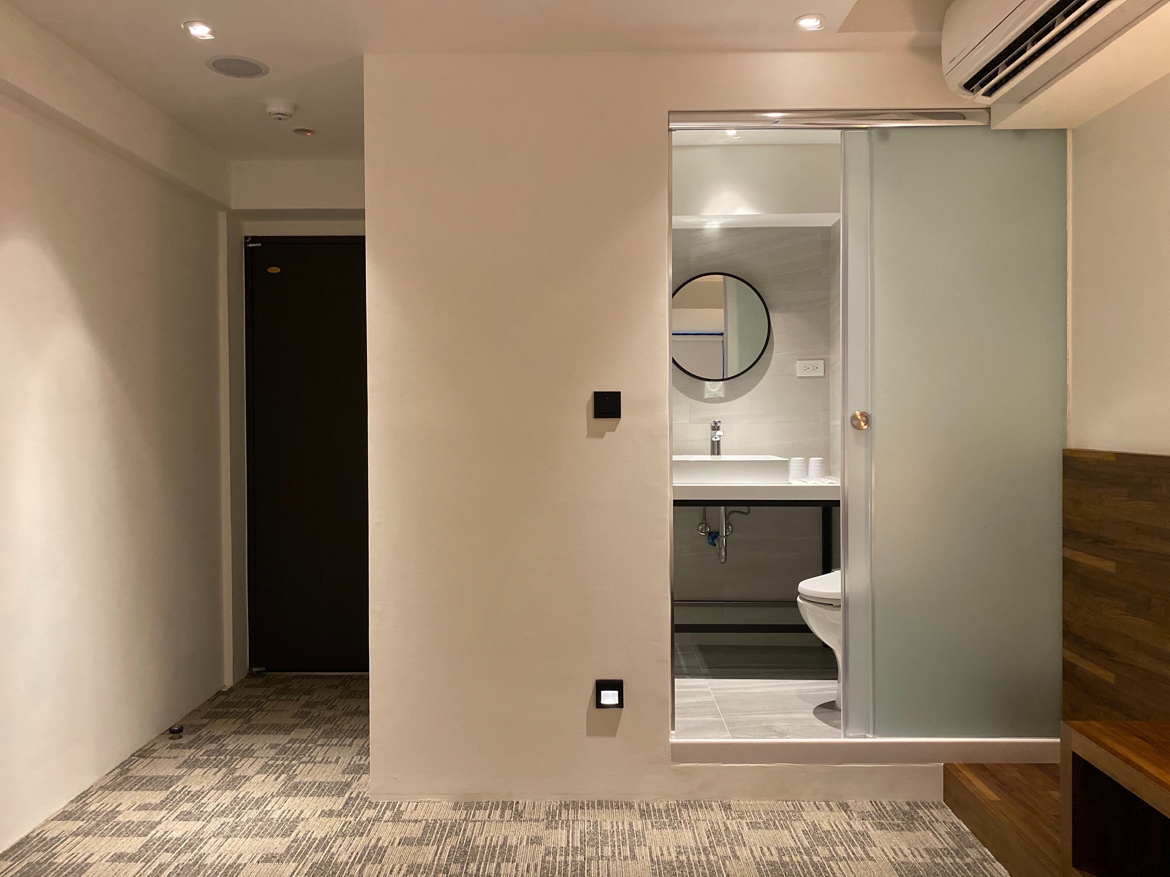 A modern bathroom with a glass shower enclosure, a sink, and a toilet.