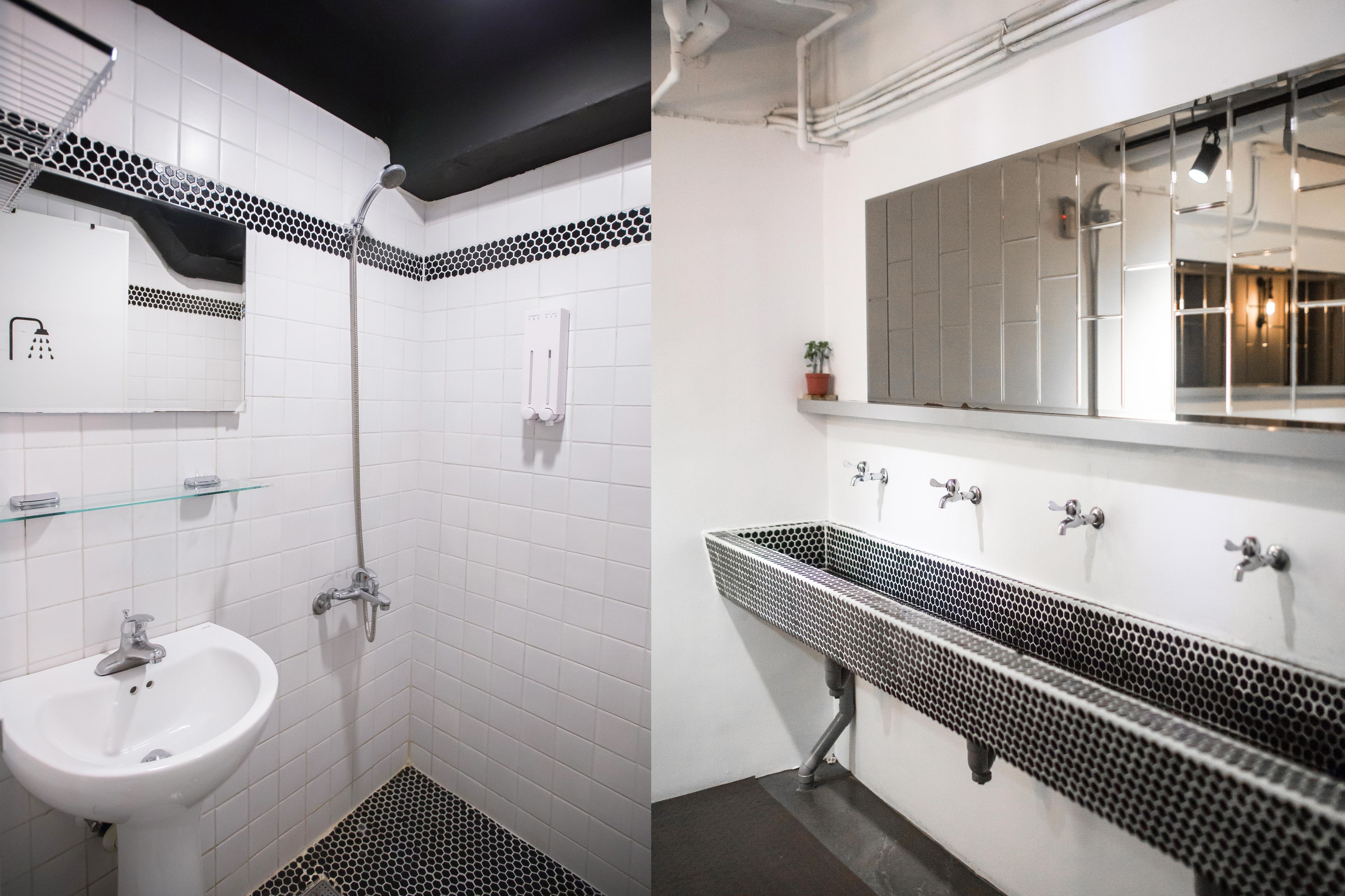 Une salle de bain avec un lavabo blanc, une douche et un grand miroir au-dessus du lavabo.