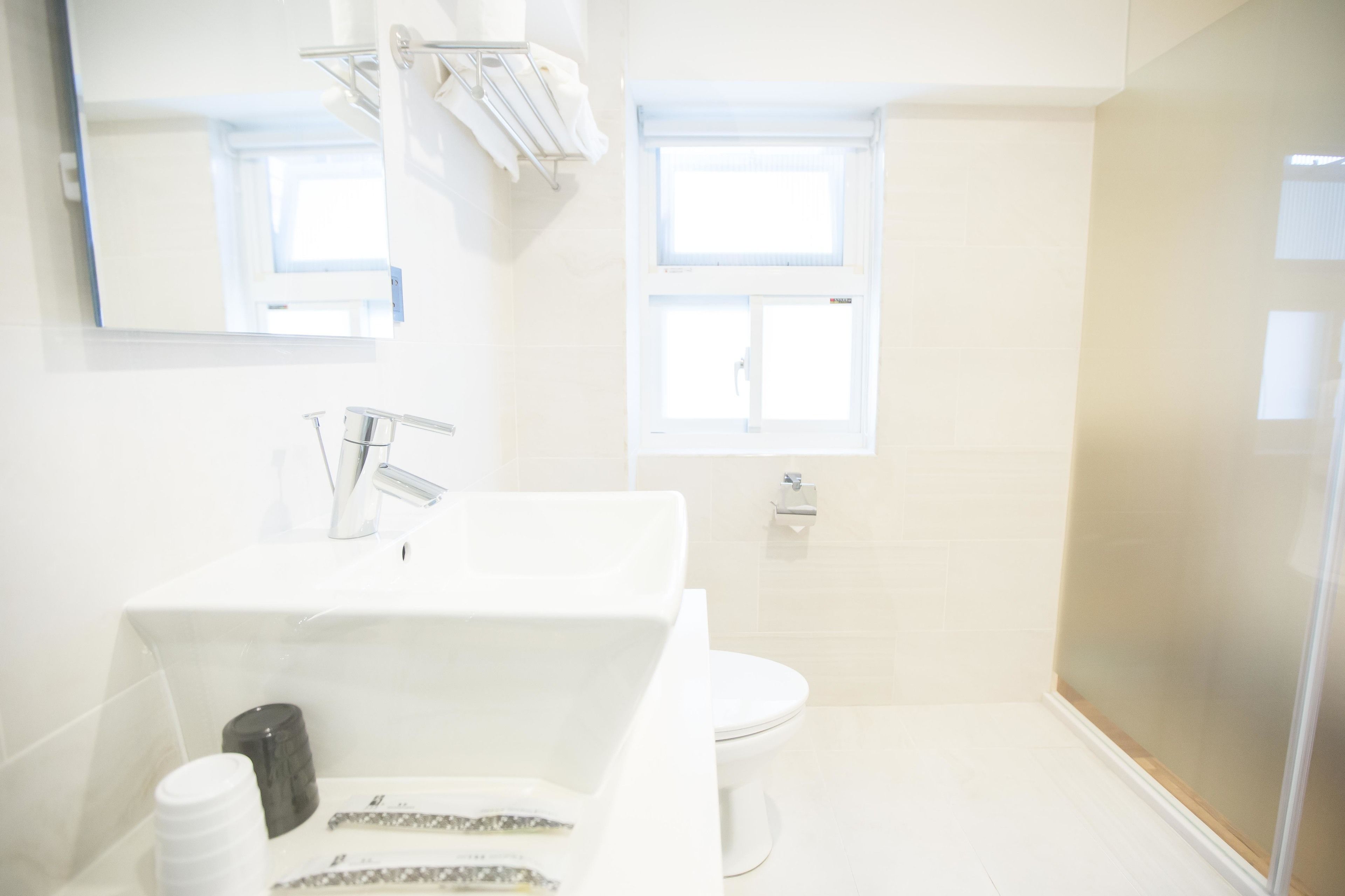 A bathroom with a white sink, a toilet, and a shower area.