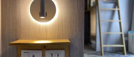 Una lámpara de pared con diseño circular e incluye un estante de madera debajo.