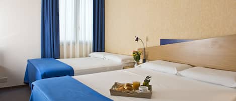 A hotel room with two beds, a breakfast tray, and a window with curtains.