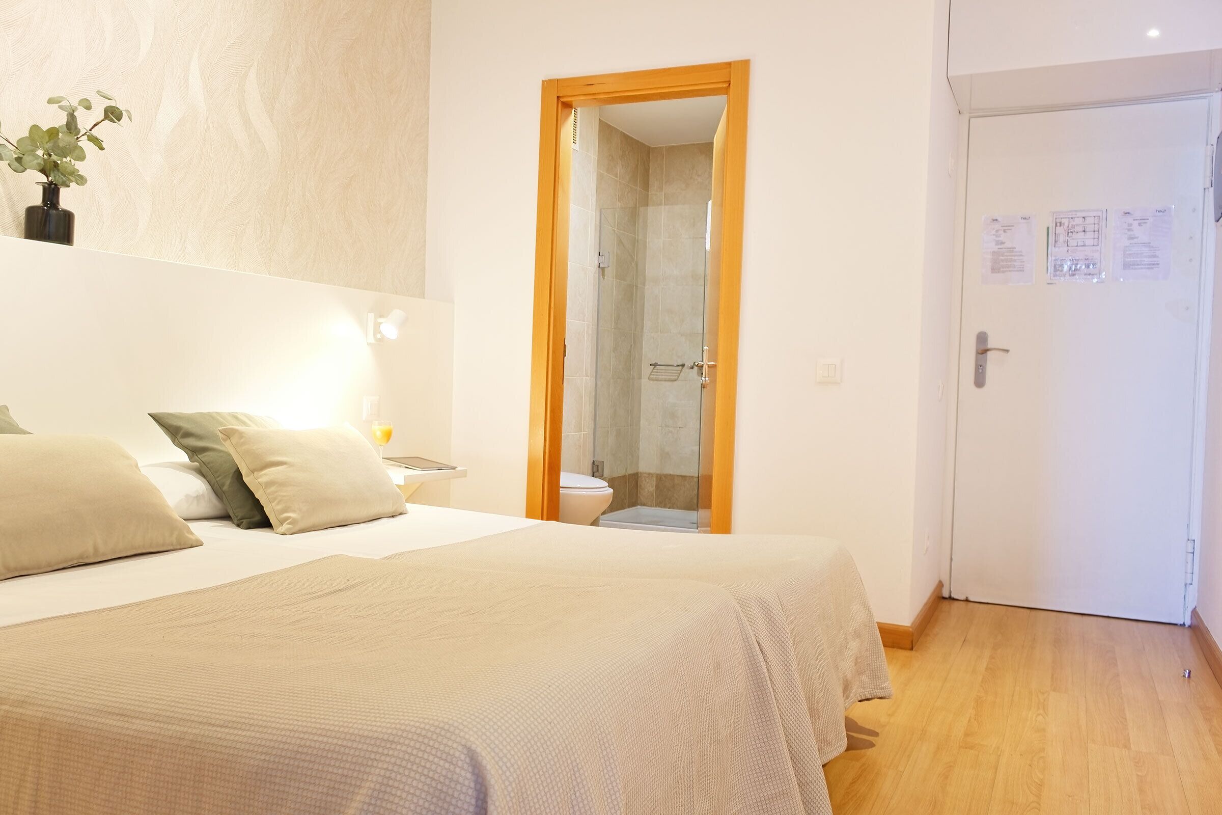 Ein Schlafzimmer mit Bett, Nachttisch und einer kleinen Pflanze.