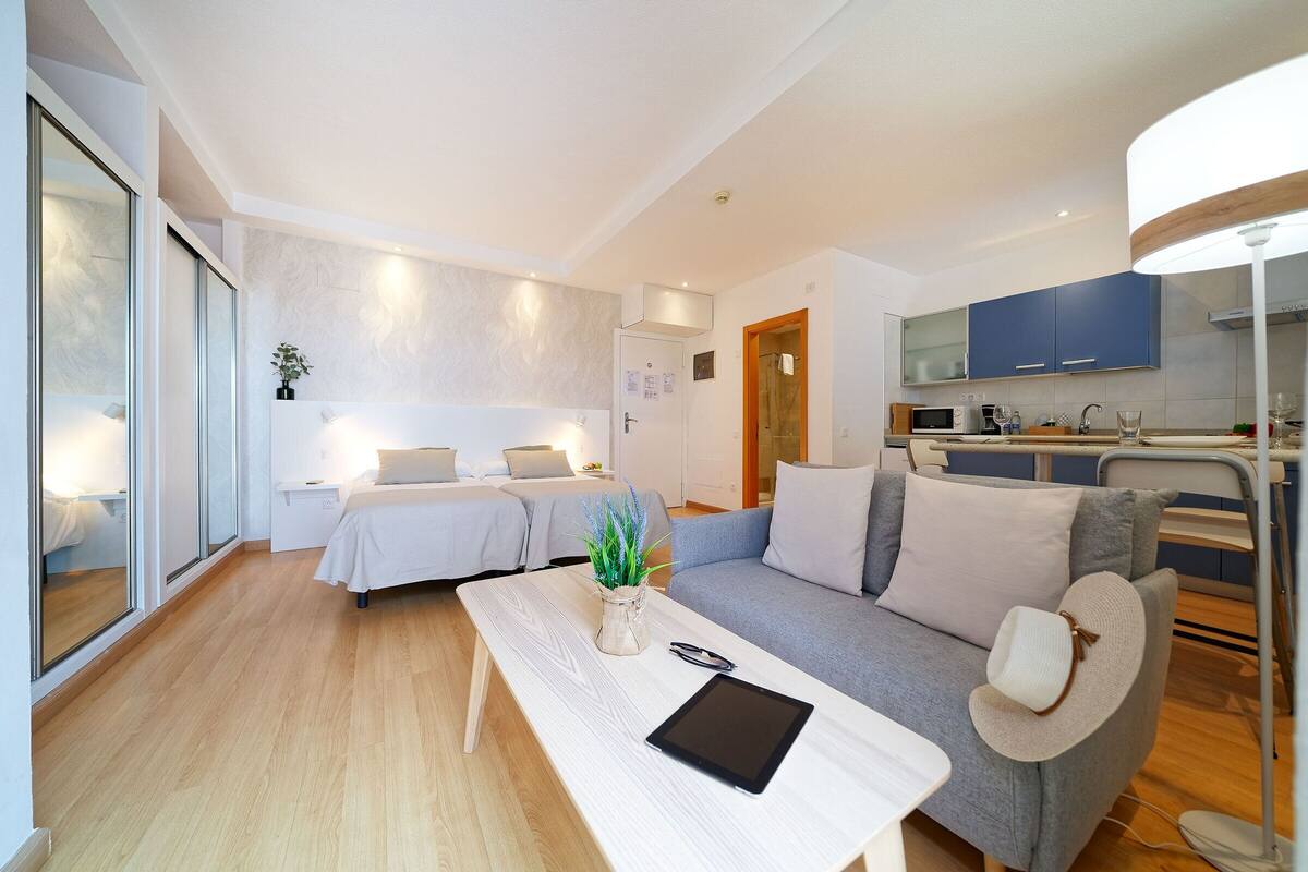 A modern, well-lit bedroom with a bed, bedside tables, and a bedside plant.