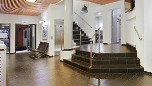 Ein modernes Interieur mit Treppe, einer Rezeption und einer Sitzecke.