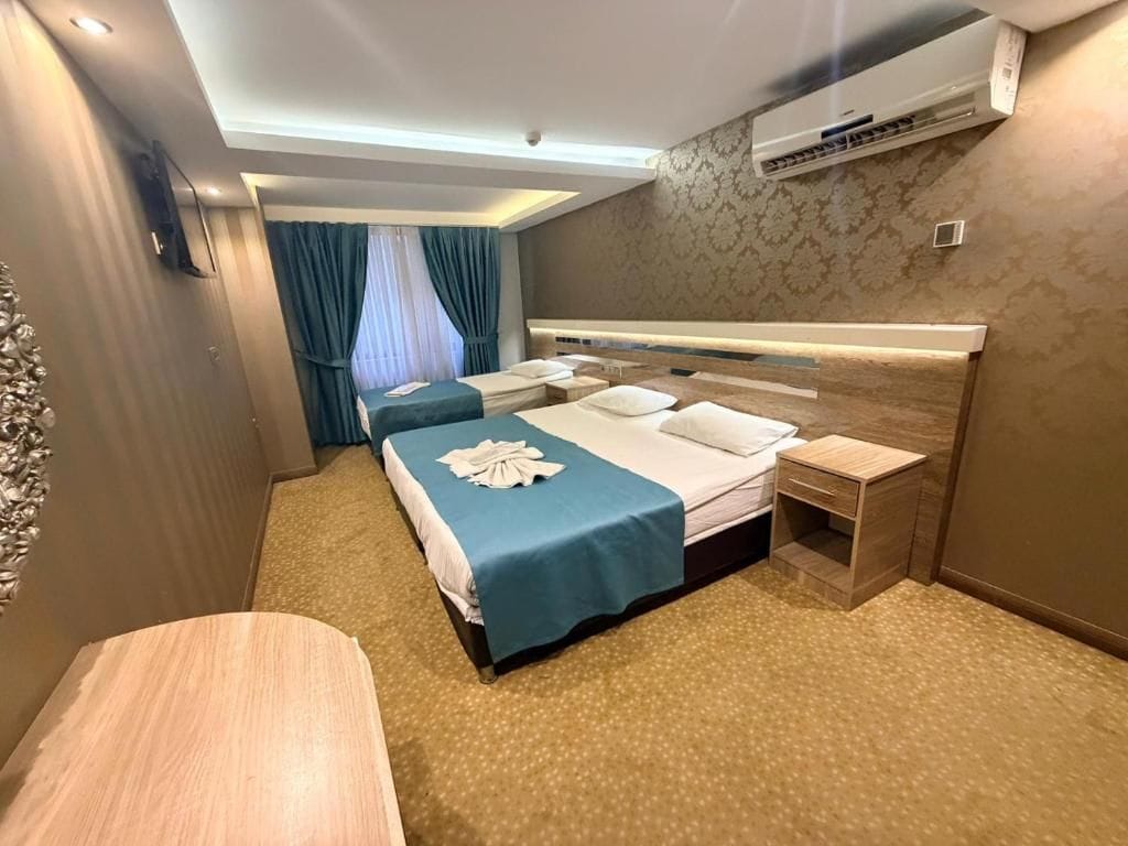 A hotel room with a bed, bedside tables, and a desk.