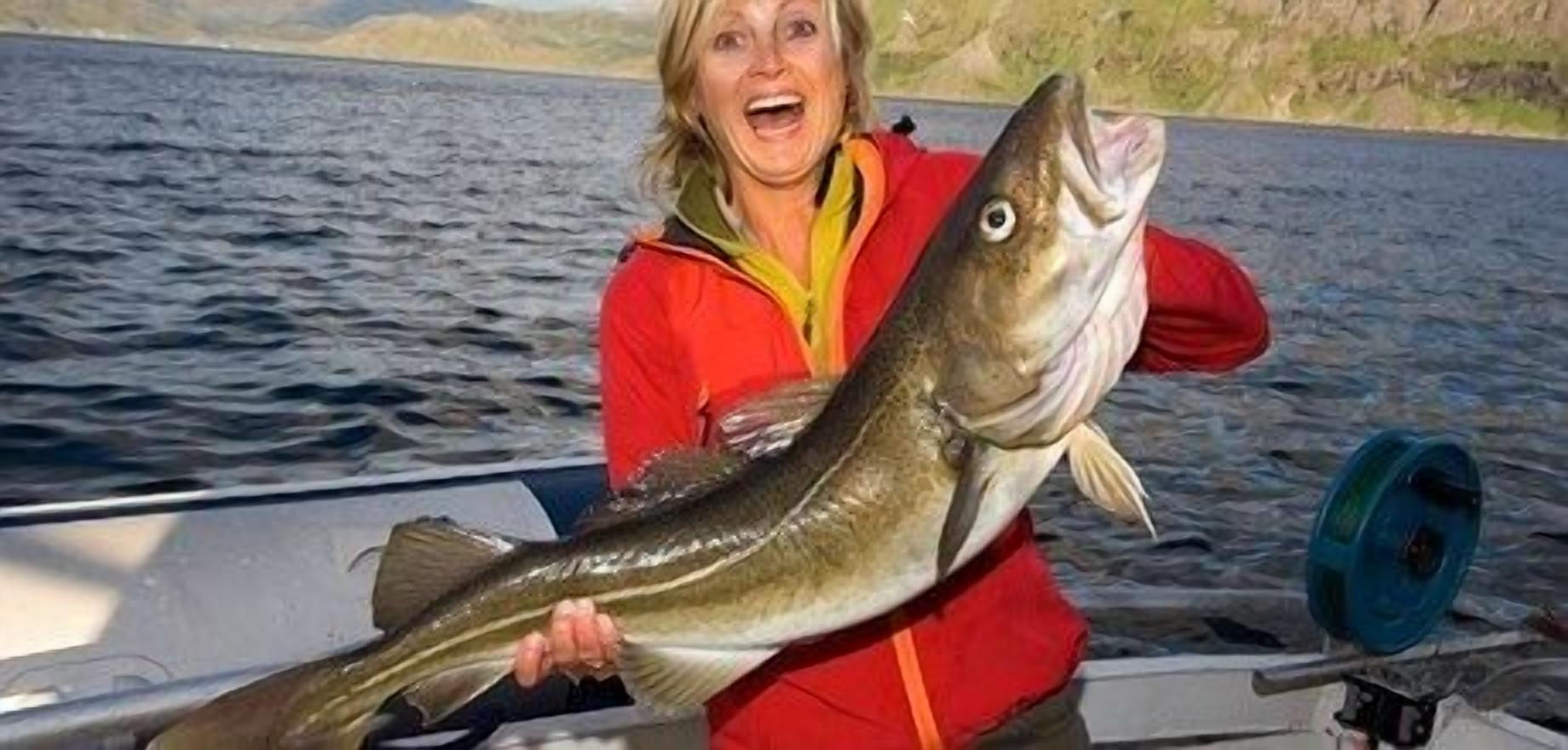 Uma pessoa segurando um peixe grande em um barco.