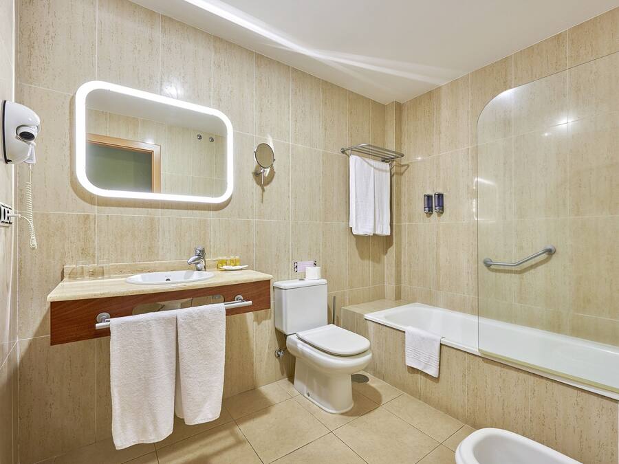 A modern bathroom with a sink, toilet, and bathtub.