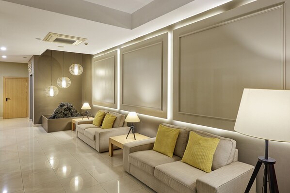 A modern hotel lobby with two sofas, a coffee table, and a floor lamp. - Hotel Benahoare (Los Llanos de Aridane)