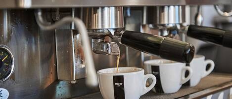 Een koffiemachine schenkt espresso in een kopje.