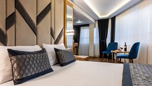 Una habitación de hotel con una cama grande, un escritorio con una silla y una mesa de comedor con una silla.