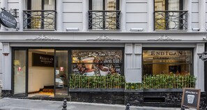 La façade de l’hôtel Endican Sultanhmet, avec sa grande vitrine décorée sur le thème du café et son panneau indicateur.