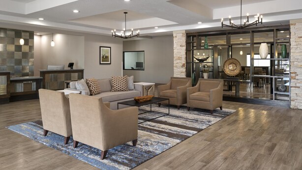 A spacious living area with a sofa set, coffee table, and a chandelier.
