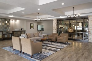 A spacious living area with a sofa set, coffee table, and a chandelier. - Best Western Plus College Station Inn & Suites (College Station)