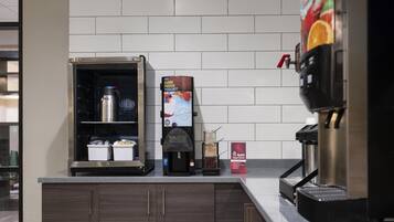 A coffee station with a coffee machine, a milk frother, and a sign for 'Farm Fresh Yogurt.'