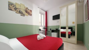 A hotel room with a bed, a desk, a chair, a TV, and a wardrobe. - Dandi Domus (Rome)
