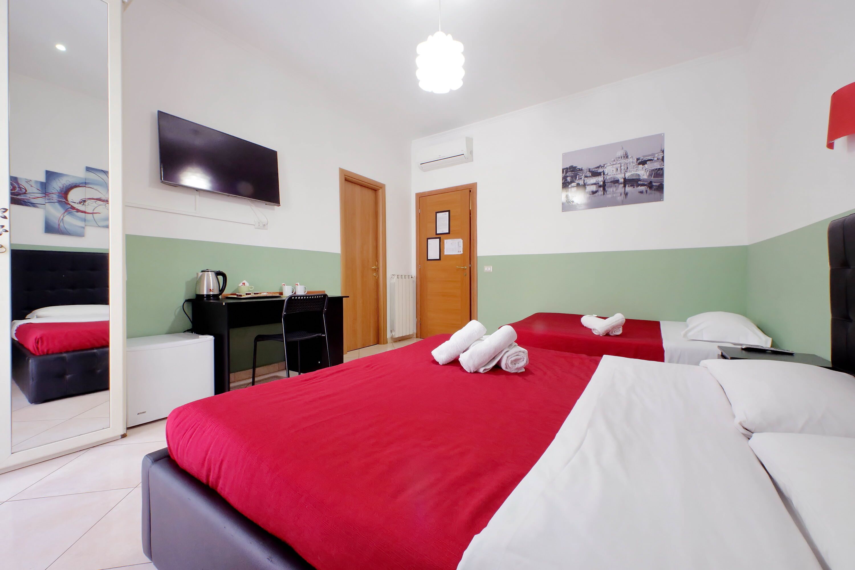 Une chambre d’hôtel avec un grand lit, un bureau, une chaise, une télévision et une porte.