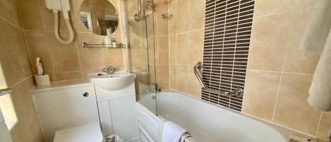 A bathroom with a toilet, sink, and bathtub.
