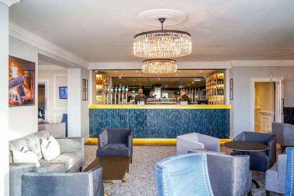 A hotel lobby with a bar area, seating arrangements, and a chandelier. -  Doric Hotel (Blackpool)