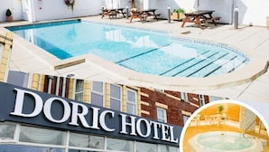 Un HOTEL DORIC con piscina, mobiliario exterior y bañera de hidromasaje.