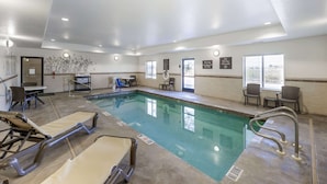 A hotel pool area with lounge chairs, a table, and chairs. - Sleep Inn & Suites Carlsbad Caverns Area (Carlsbad)
