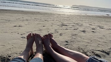 Perto da praia, areia branca, espreguiçadeiras, guarda-sóis