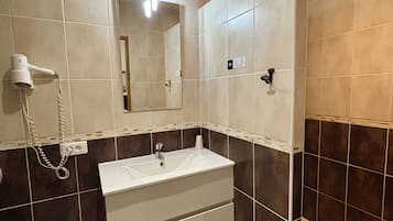 A bathroom with a sink, mirror, and hairdryer.