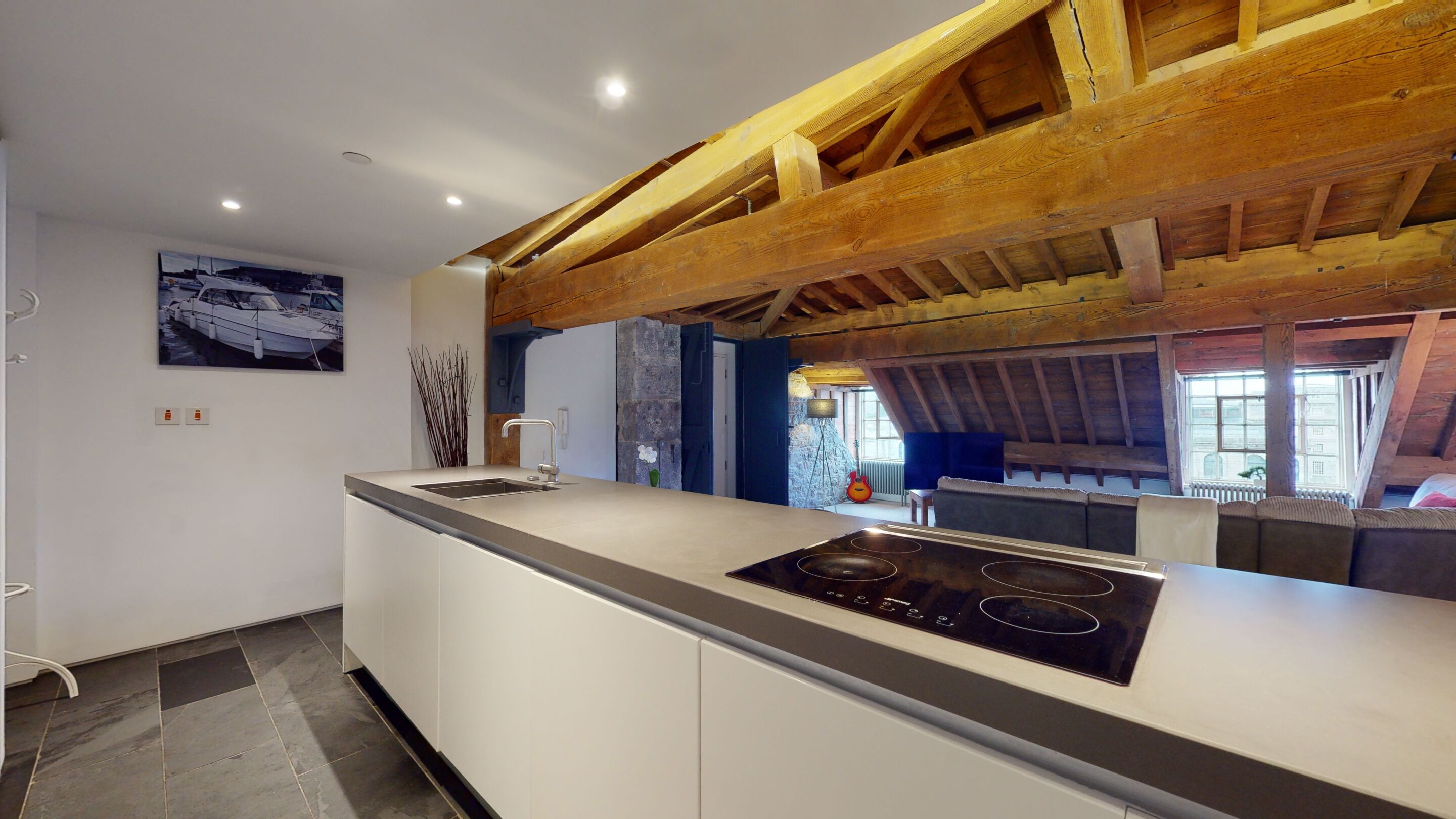 Una cocina moderna con estufa integrada, un lavamanos y una pared de piedra.
