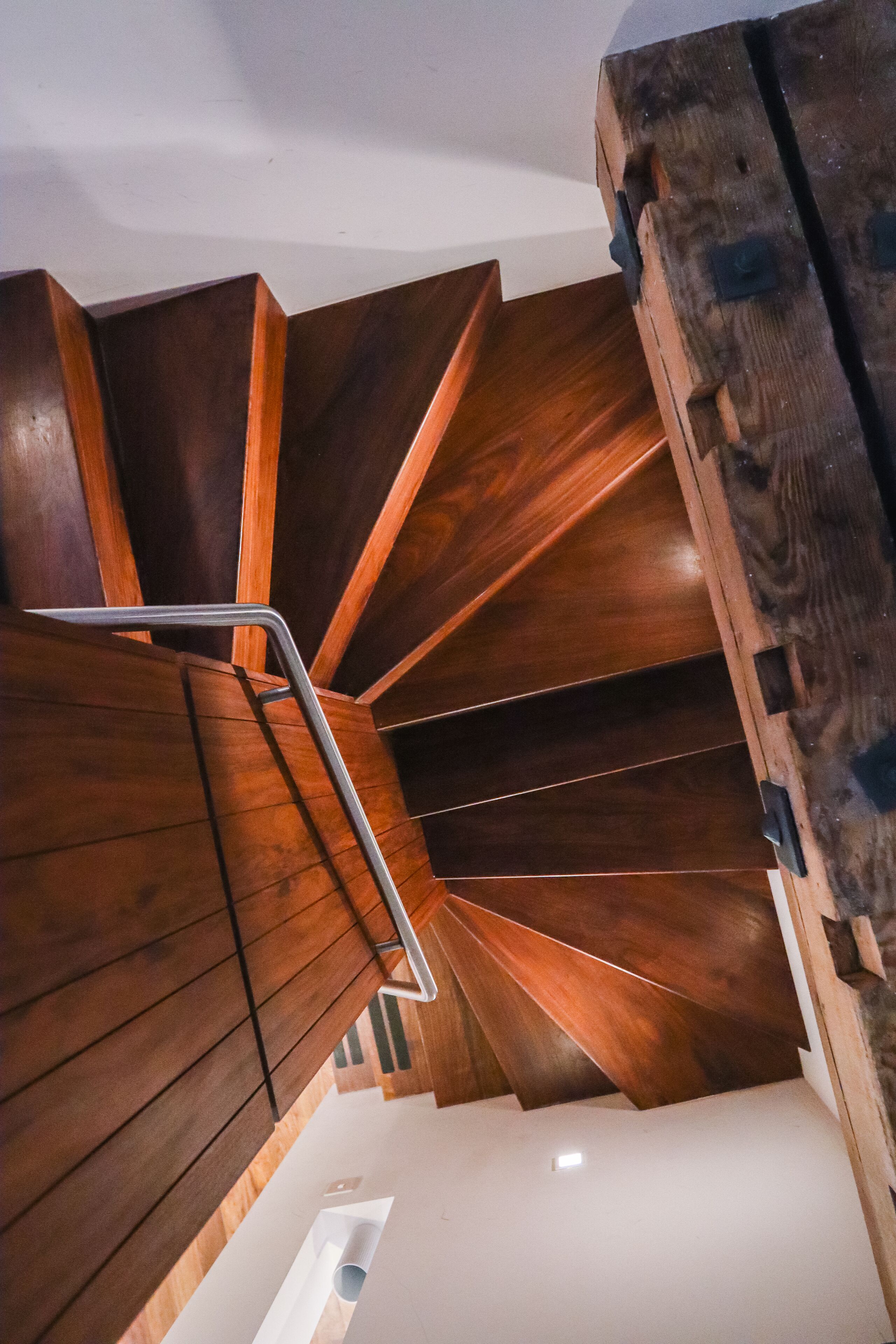 A spiral staircase with wooden steps and metal handrails.