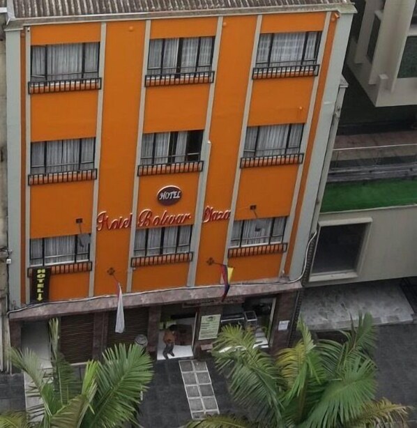 Un hôtel à plusieurs étages, avec une façade orange et des balcons.