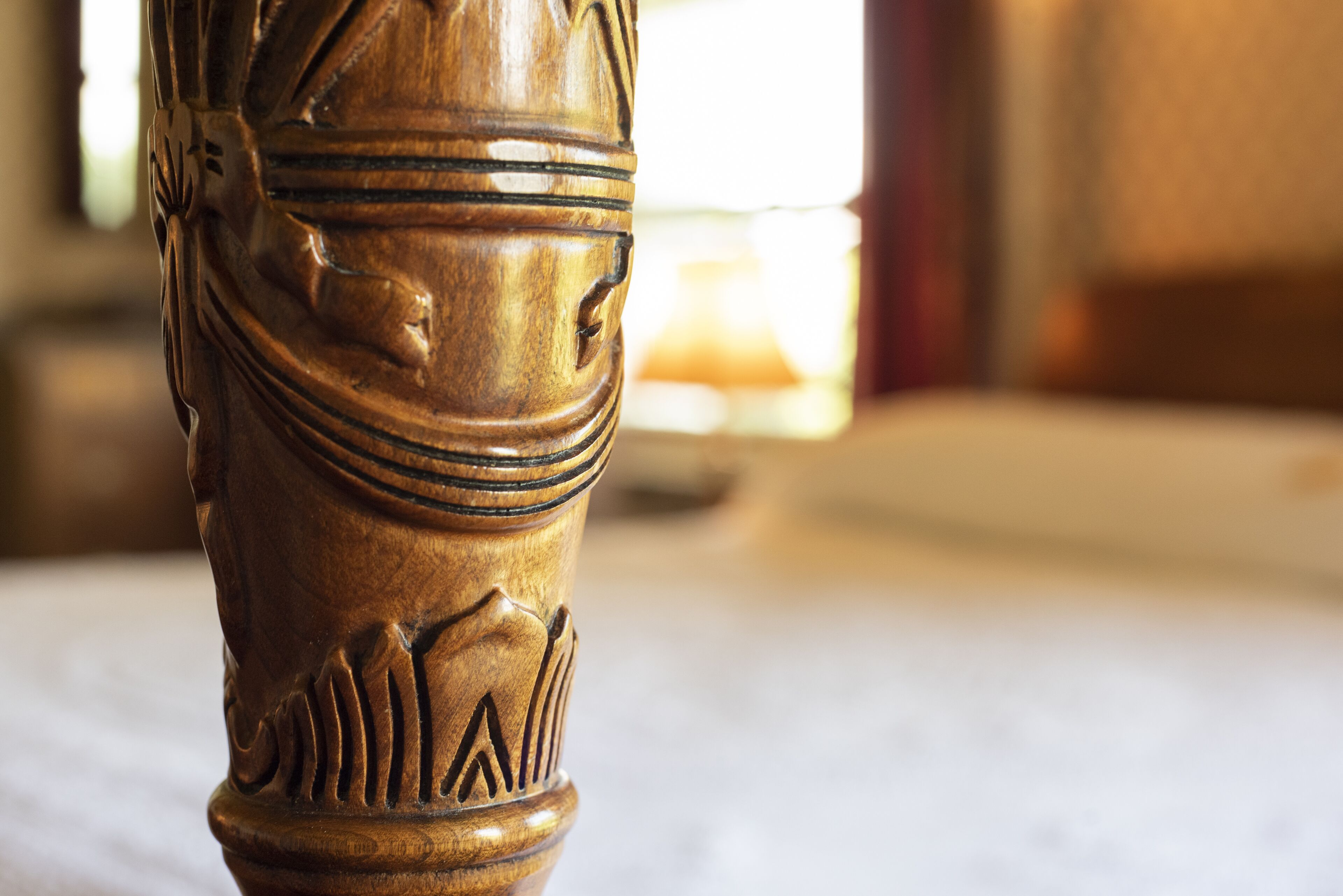 A close-up of a wooden chair leg with carved details.