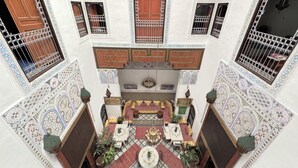 A courtyard with a central seating area, patterned walls, and decorative tiles. - Riad Meski (Fes)