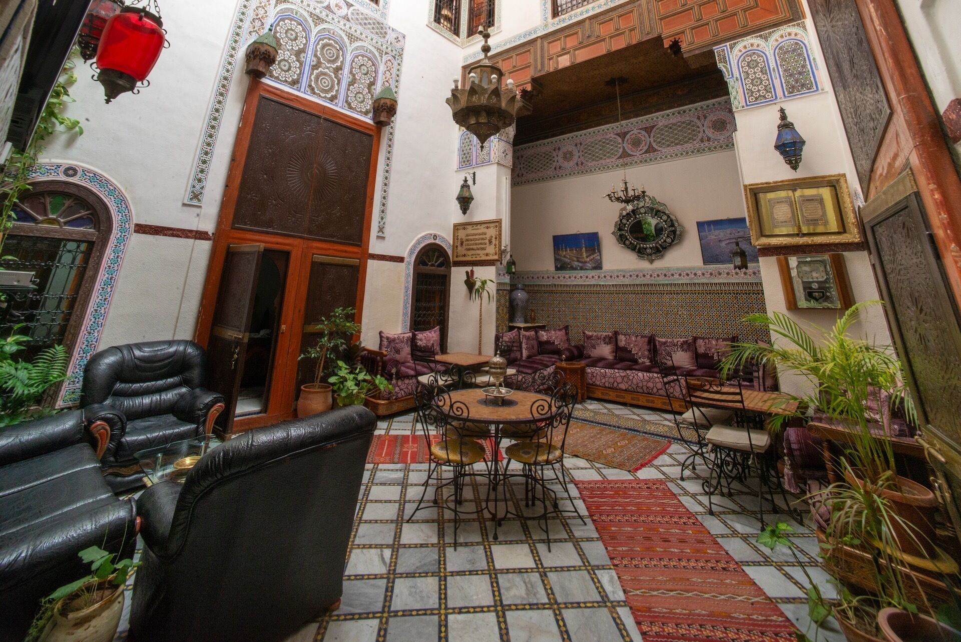 Un interior tradicional marroquí con una zona de estar, suelo estampado y elementos decorativos.