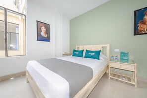 A hotel room with a bed, a nightstand, a window, and two wall-mounted pictures. - Ayenda Ana Carolina (Manizales)