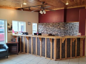 A kitchen with a stone backsplash, wooden counter, and a ceiling fan. - Econo Lodge Springerville (Springerville)