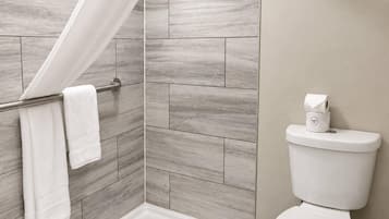 A bathroom with a shower, toilet, and a towel rack.
