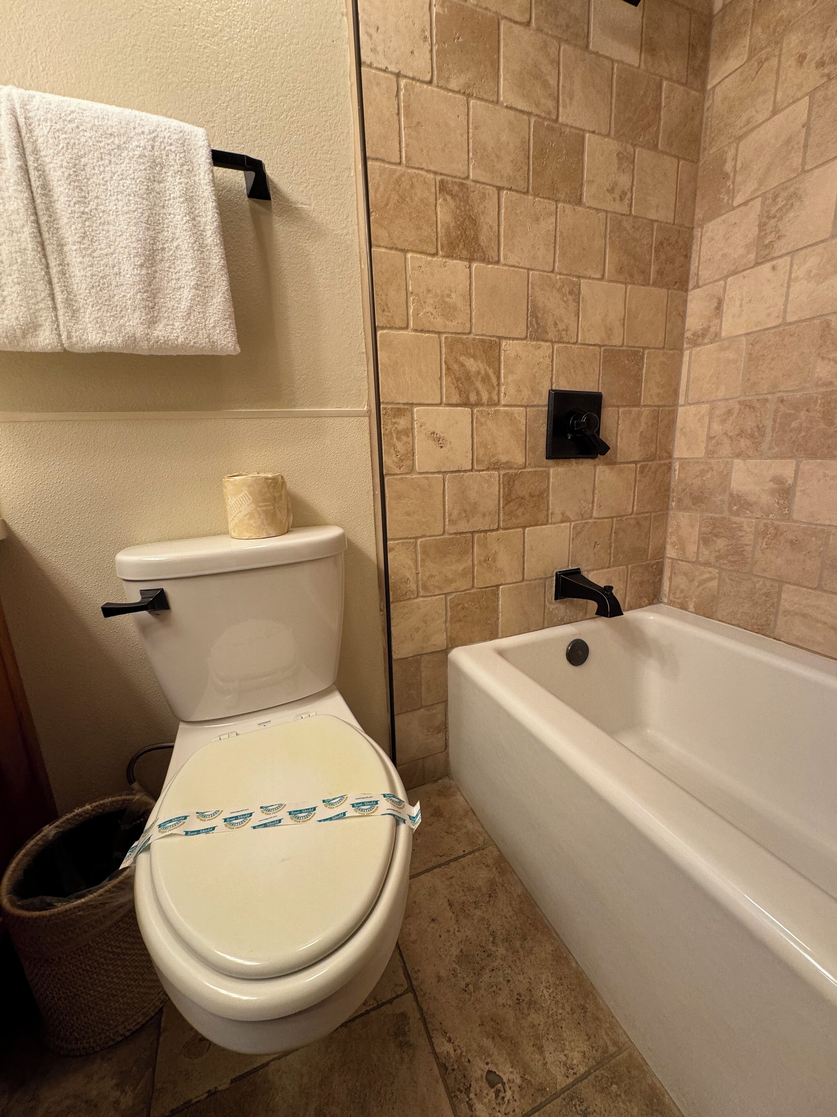 Une salle de bain comprenant des toilettes, une baignoire et un espace douche.