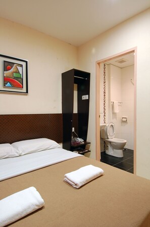A hotel room with a bed, a bathroom visible through an open door, and a framed artwork on the wall. - Impiana Mutiara Hotel (Kota Kinabalu)