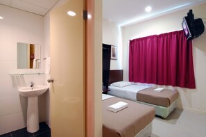 A hotel room with a sink, a bed, two bedside tables, and a television mounted on the wall. - Impiana Mutiara Hotel (Kota Kinabalu)