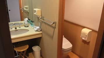 Baño pequeño con lavamanos, espejo, inodoro y secamanos.
