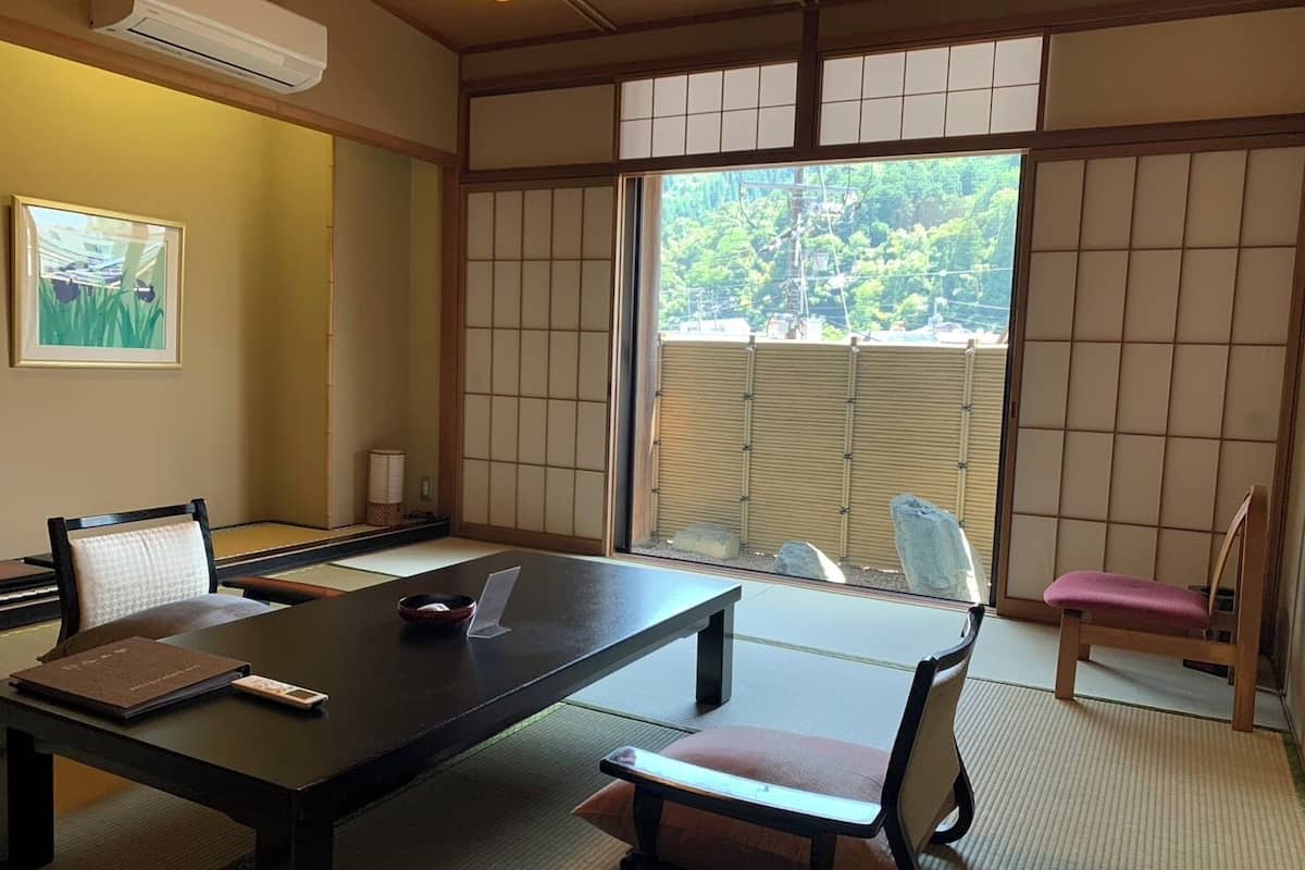 Een traditionele Japanse kamer met tatami vloerbedekking, een lage tafel en shoji schermen.