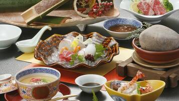 A variety of Japanese dishes arranged on a table, including sushi, sashimi, and other seafood items.