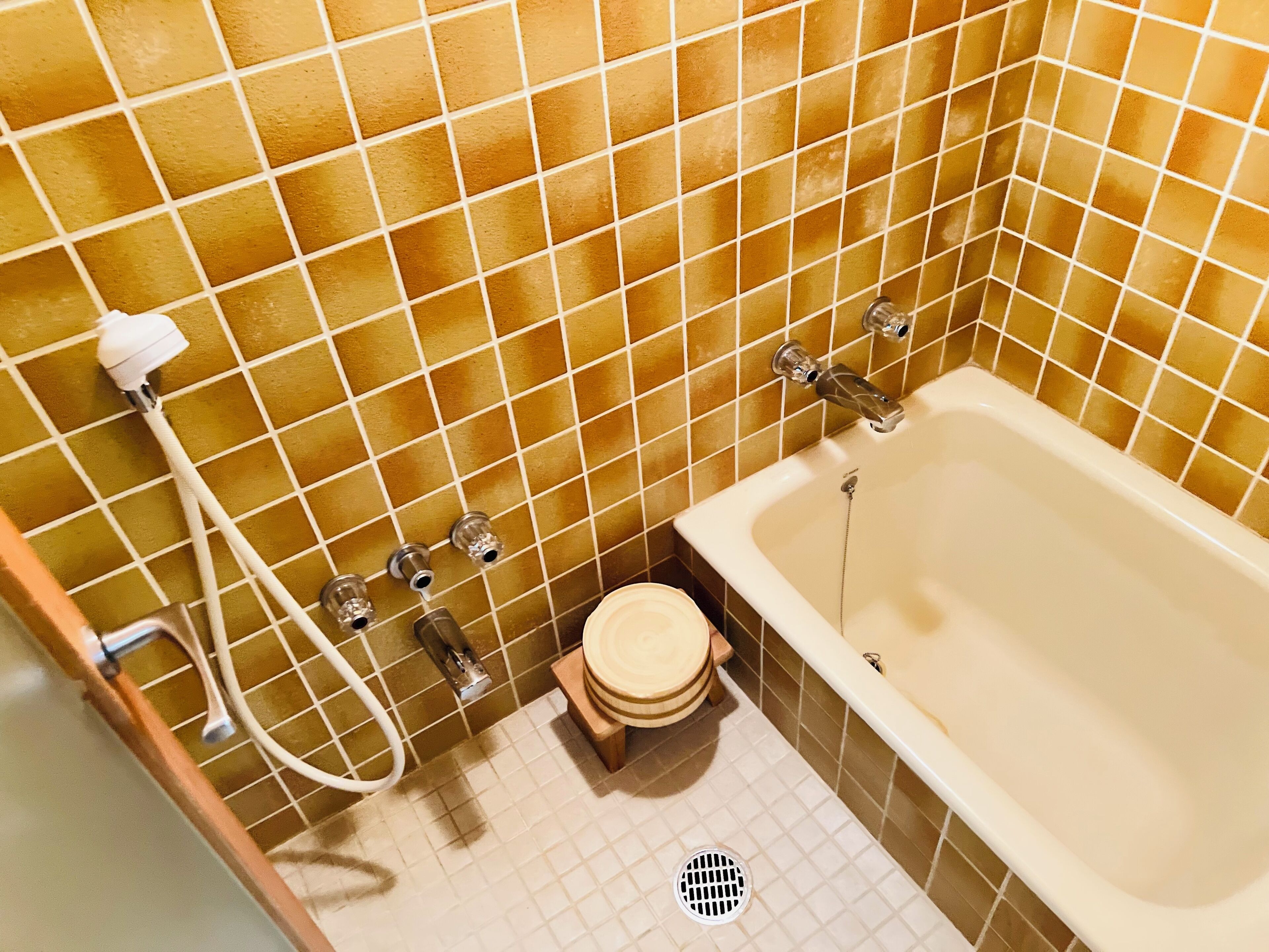 A bathroom with a bathtub, a toilet, and a shower area.