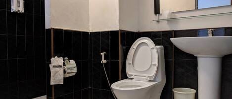 A modern bathroom with a toilet, bidet, and sink.
