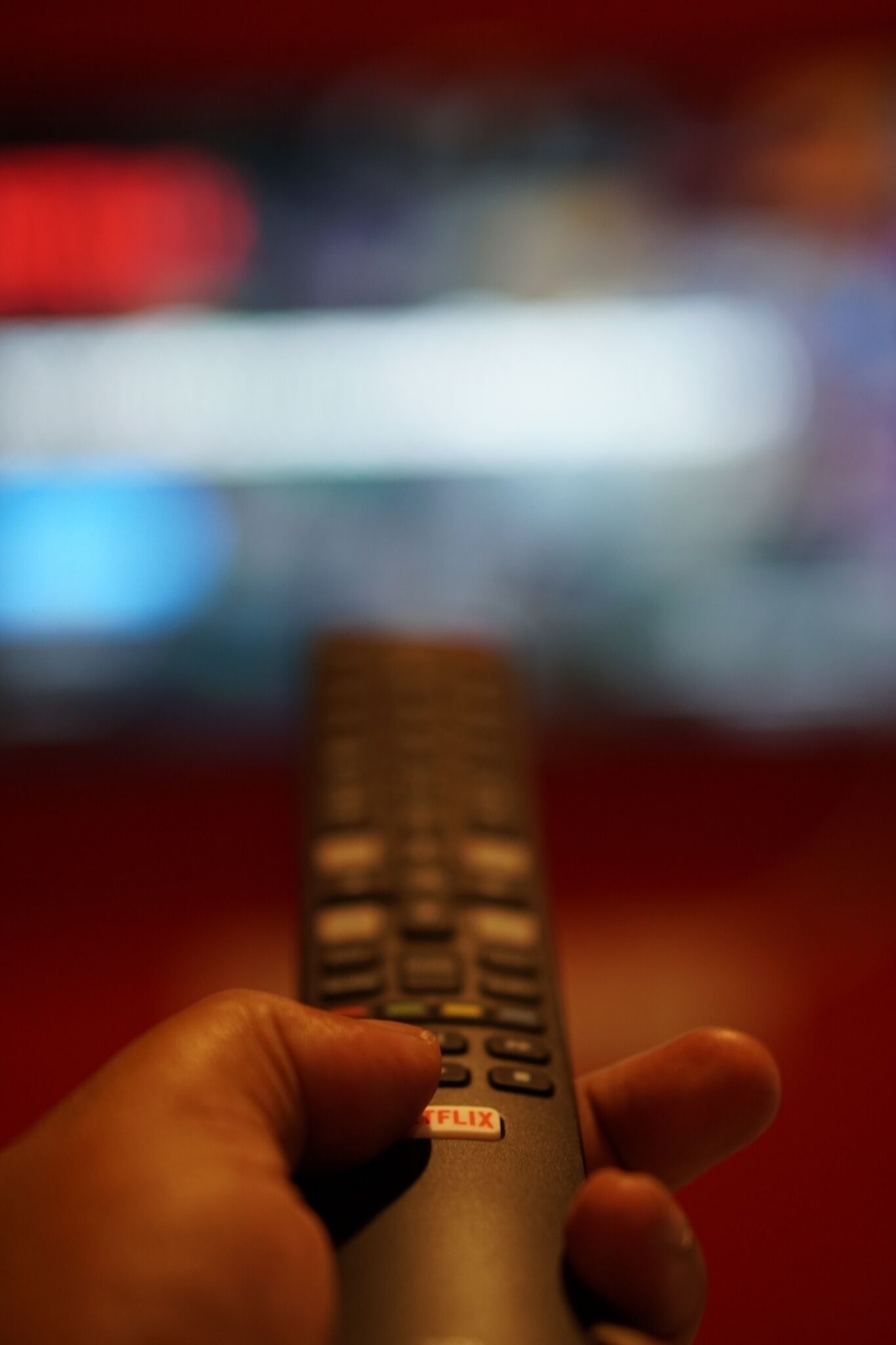 A hand holding a remote control with a visible 'FLIX' button.
