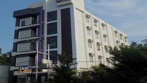 A multi-story hotel with a modern design, featuring a prominent 'M' logo on the facade. - Miracle Hotel Manado (Manado)