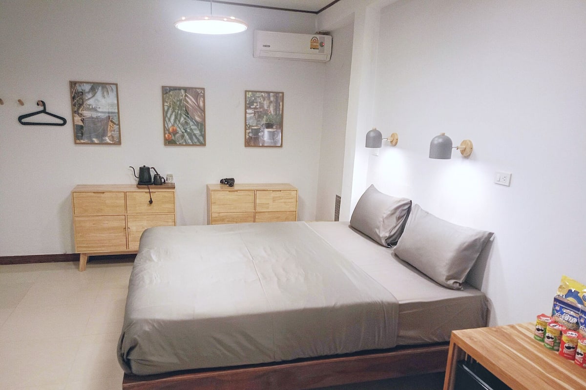 Une chambre à coucher avec un lit, deux commodes en bois, une petite table avec des collations et des décorations murales.