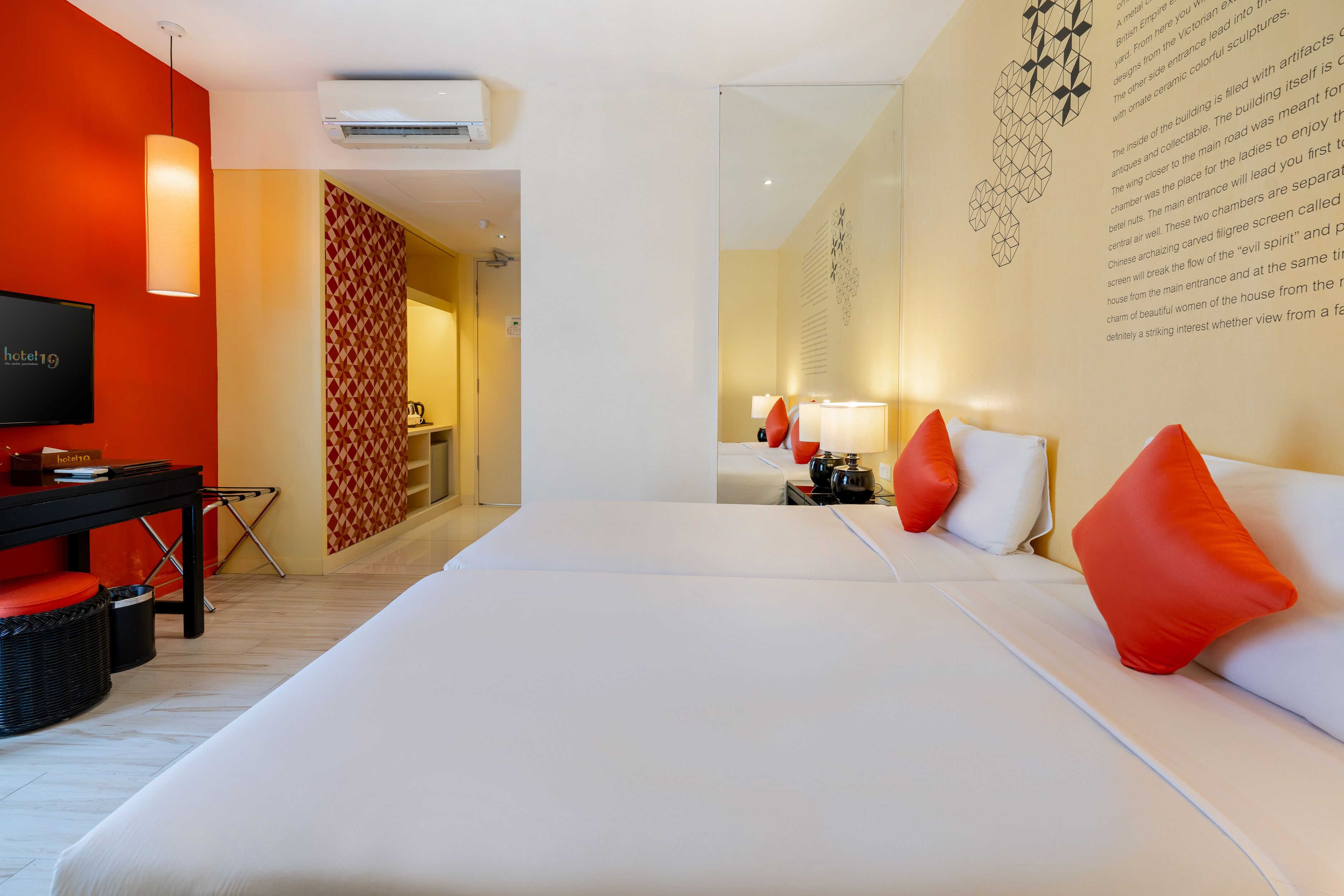 A hotel room with a large bed, a desk, and a TV.