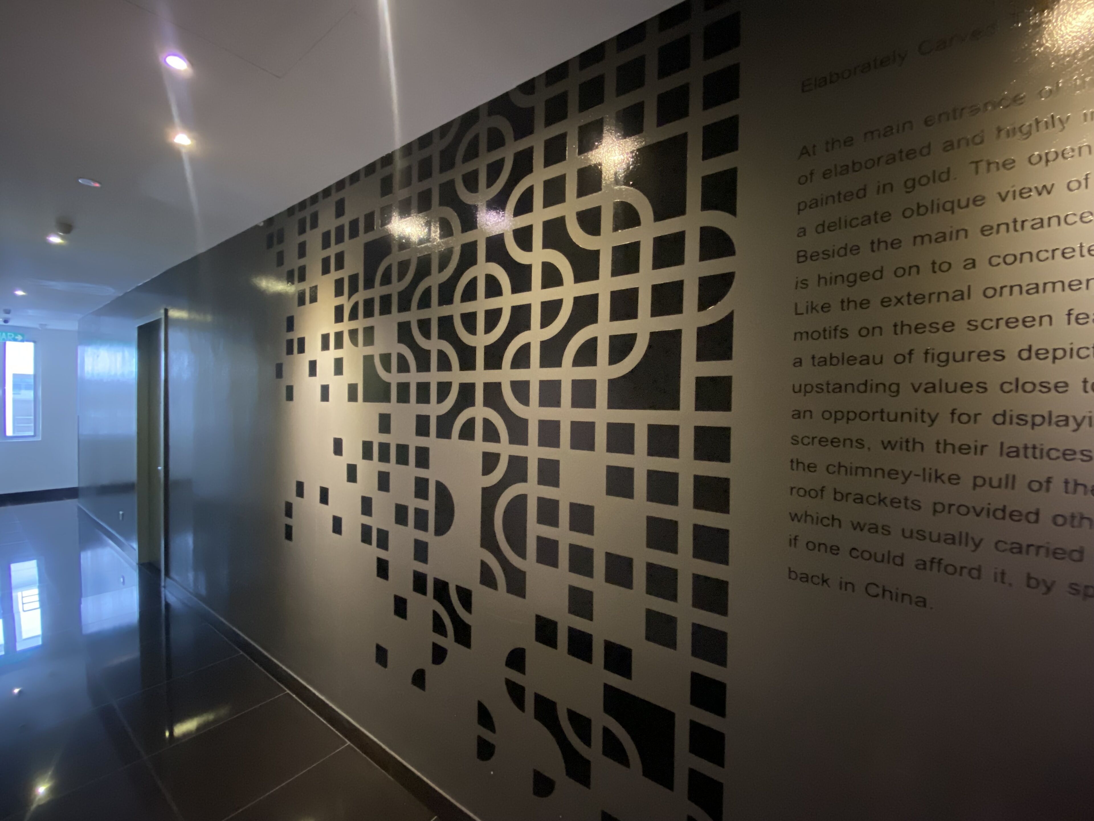 En modern inredning med en vägg som har ett geometriskt mönster och ett reflekterande golv.