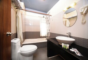A bathroom with a toilet, sink, and bathtub. - Hotel Amaryllis (Kathmandu)